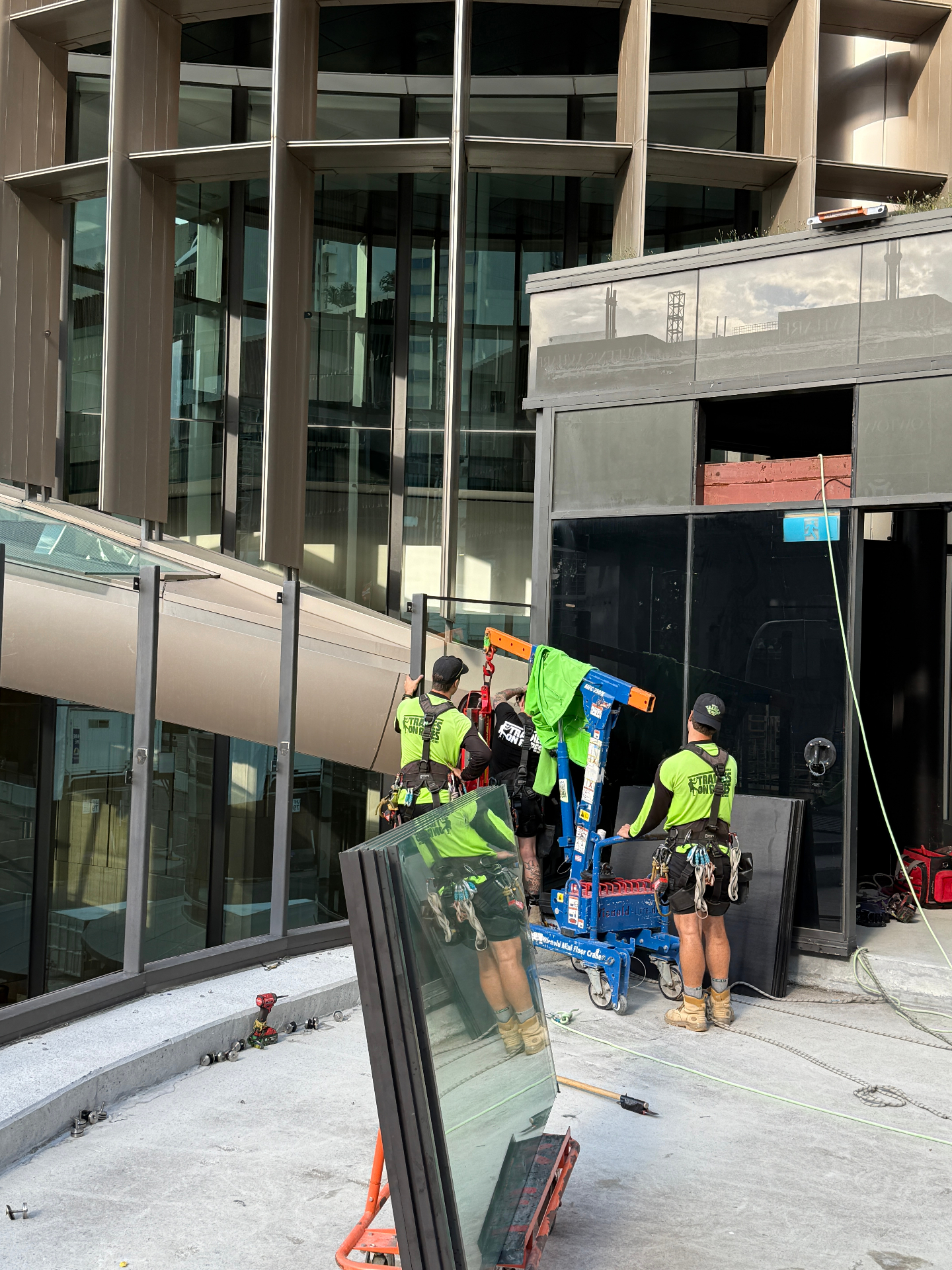 Tradies on Ropes glaziers loading glass onto a Wienold mini floor crane at 1 William Street Brisbane
