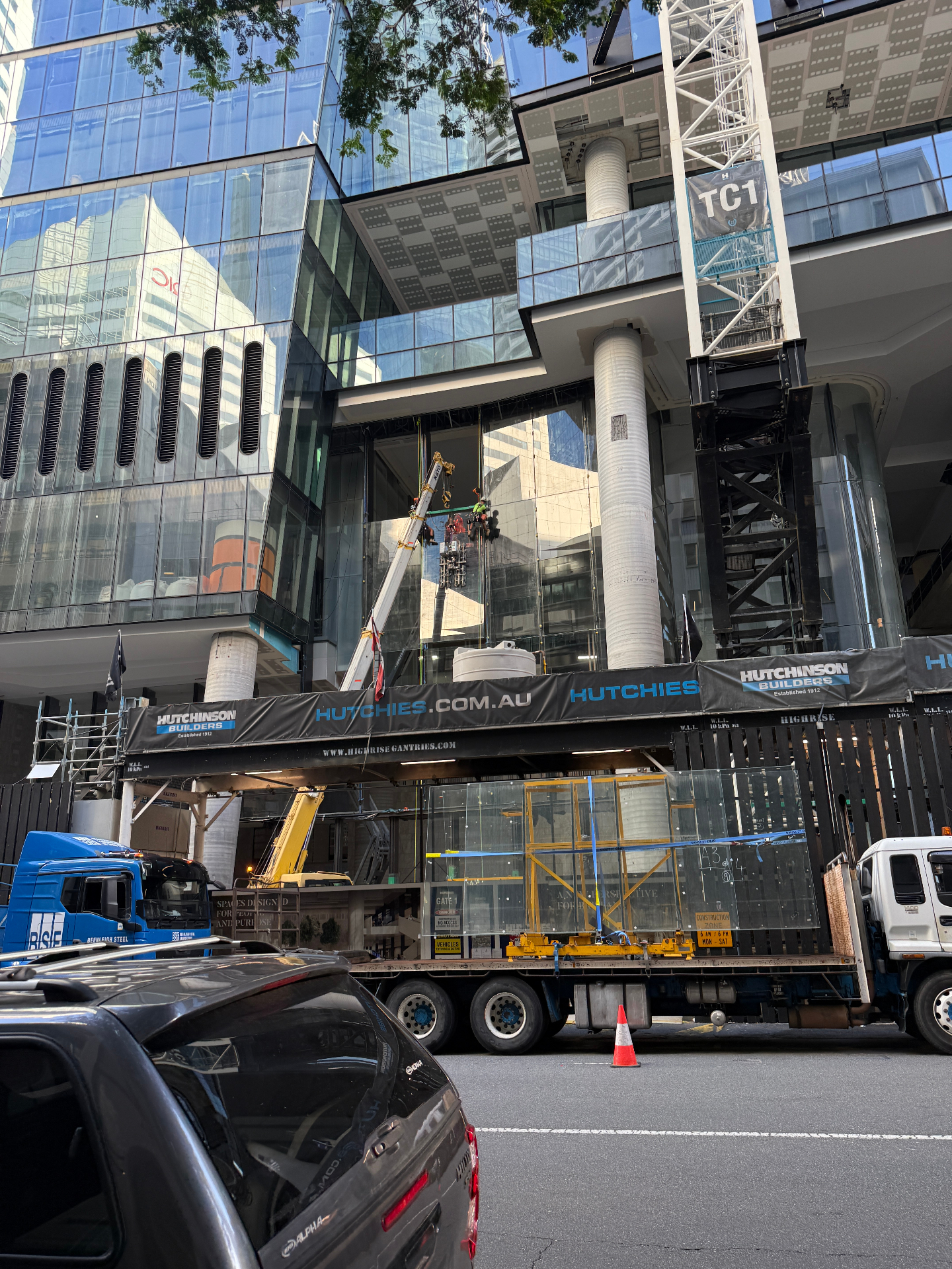 Street view of 360 Queen Street Brisbane with glass panel being craned into the façade