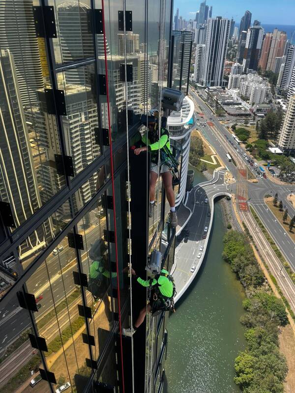 Trade qualified rope access technician performing façade work on a high-rise building