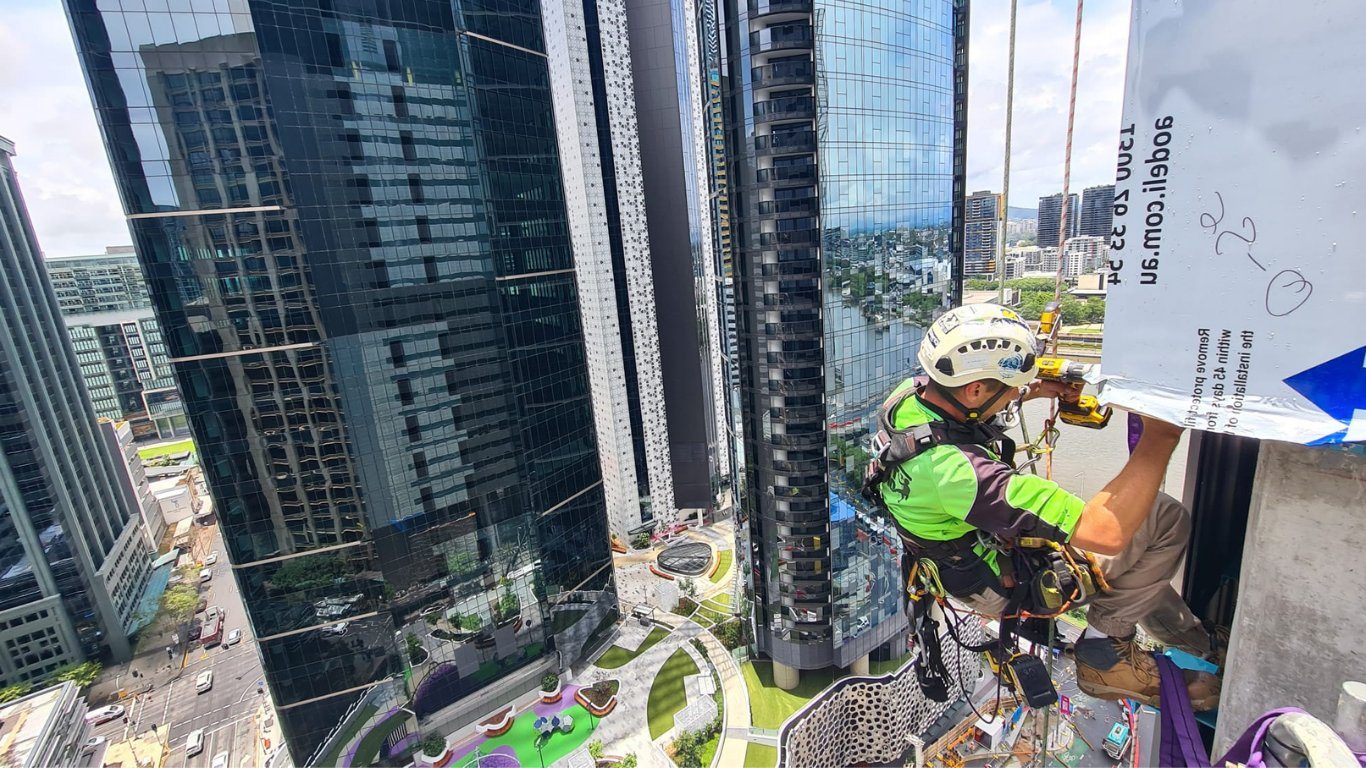 Trade qualified rope access technician performing façade work on a high-rise building